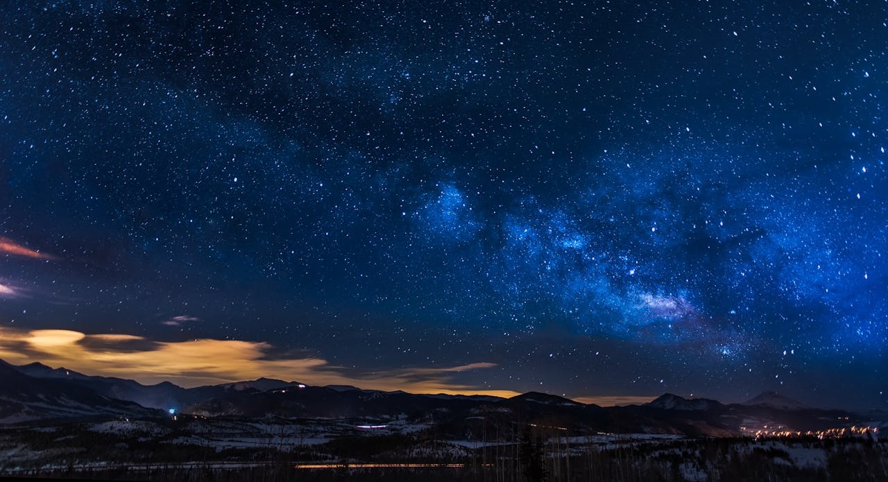 A breathtaking view of the Milky Way galaxy illuminating the night sky over mountains.